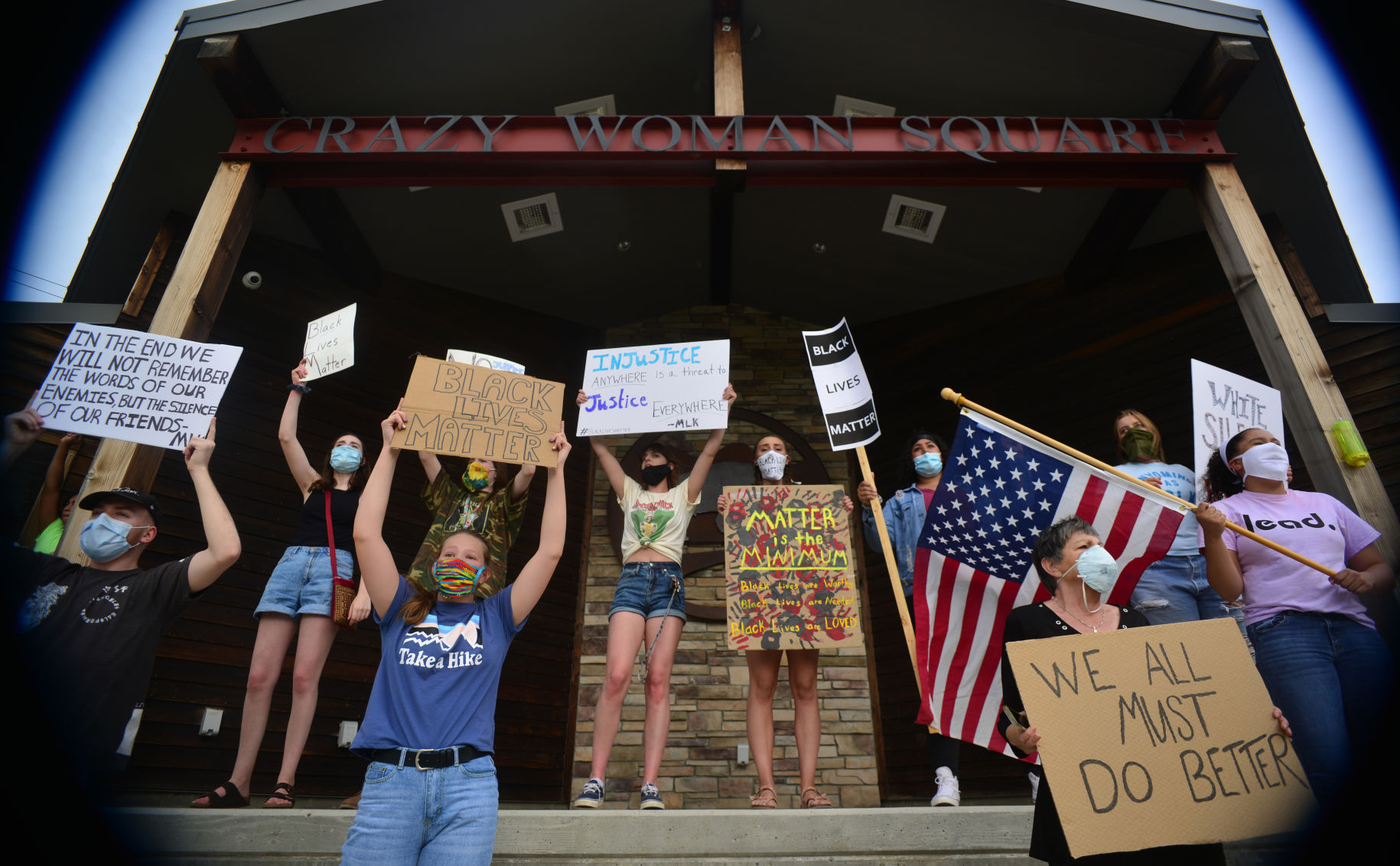Black Lives Matter protestors spread out on the stage and in the grass to chant